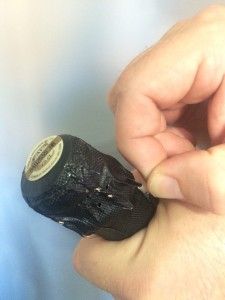 Abrir una botella de champagne o cava. Imagen. Tiramos del cuadradillo con la mano derecha. Abrir una botella de champagne o cava.
