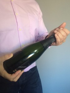 Abrir una botella de champagne o cava. Imagen. La mano Izquierda la deslizamos hacia arriba y procedemos a quitar el capuchón. Abrir una botella de champagne o cava.